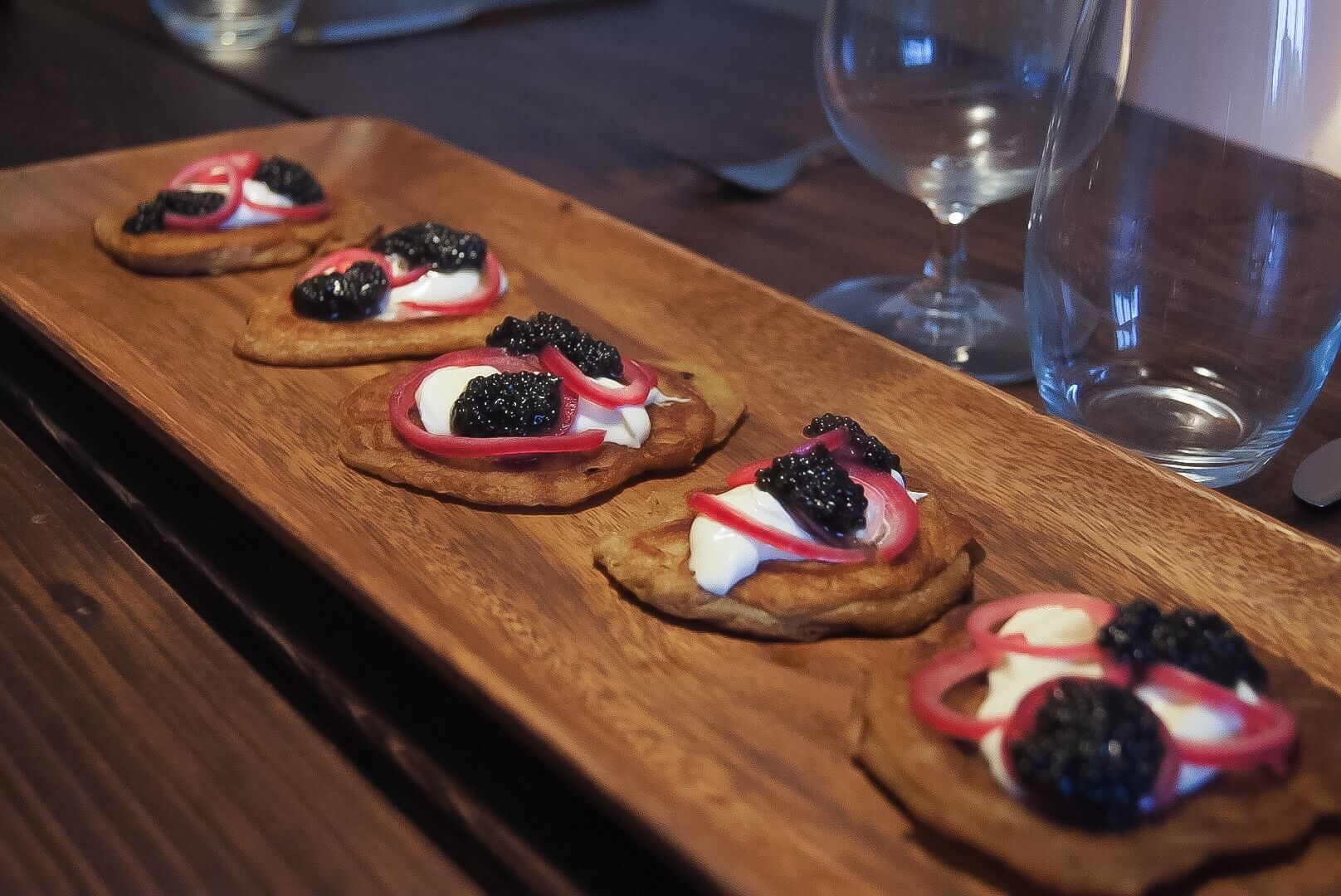 Hjemmelavede blinis med cremefraiche, syltede rødløg og caviar